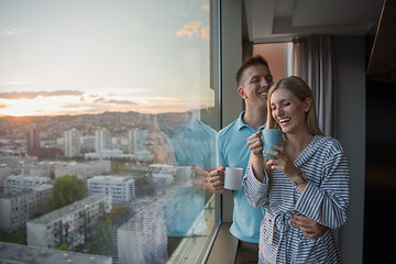 Image showing young couple enjoying evening coffee by the window