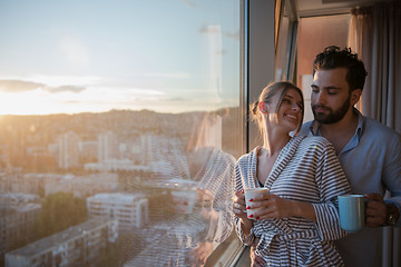 Image showing young couple enjoying evening coffee by the window