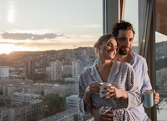 Image showing young couple enjoying evening coffee by the window