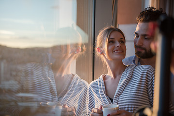 Image showing young couple enjoying evening coffee by the window