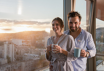 Image showing young couple enjoying evening coffee by the window