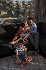 Image showing happy young couple spending time with kids at home