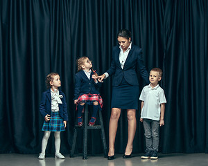 Image showing Cute stylish children on dark studio background. The beautiful teen girls and boy standing together