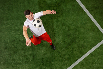 Image showing Football player tackling ball over green grass background