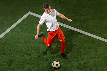 Image showing Football player tackling ball over green grass background