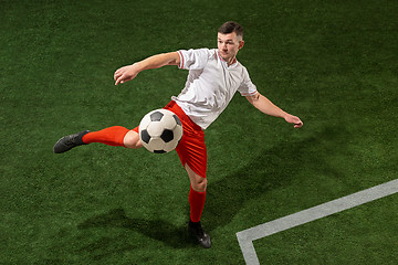 Image showing Football player tackling ball over green grass background