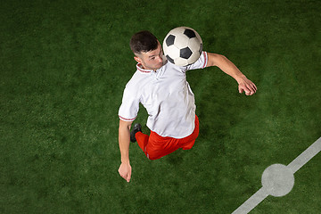 Image showing Football player tackling ball over green grass background