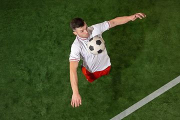 Image showing Football player tackling ball over green grass background