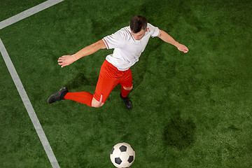 Image showing Football player tackling ball over green grass background