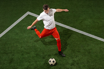 Image showing Football player tackling ball over green grass background