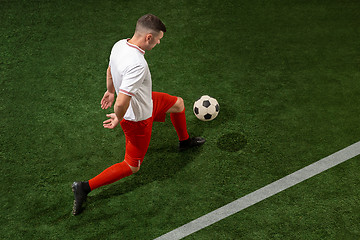 Image showing Football player tackling ball over green grass background