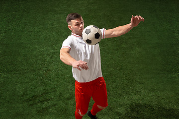 Image showing Football player tackling ball over green grass background