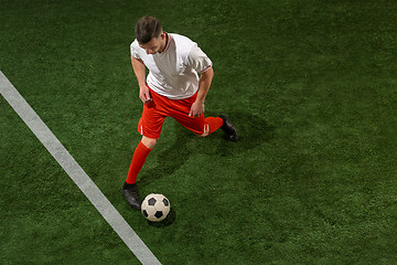 Image showing Football player tackling ball over green grass background