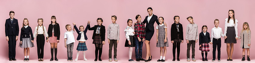 Image showing Cute stylish children on pink studio background. The beautiful t