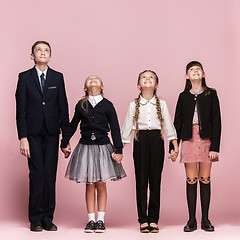 Image showing Cute stylish children on pink studio background. The beautiful teen girls and boy standing together