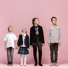 Image showing Cute stylish children on pink studio background. The beautiful teen girls and boy standing together