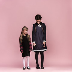 Image showing Cute stylish children on pink studio background. The beautiful teen girls standing together