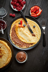 Image showing Delicious chocolate homemade pancakes on black ceramic plate