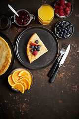 Image showing Tasety homemade pancake on black ceramic plate.