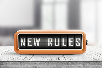 Image showing New rules alarm message on a wooden desk