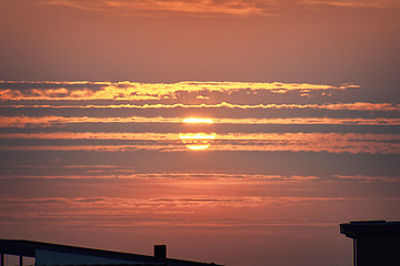 Image showing Red sunset over rooftop silhouette