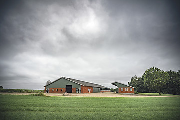 Image showing Farm under a cloudy sky with green fields