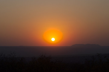 Image showing Red sunset over a large area with hills