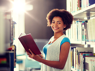 Image showing happy african student girl reading book at library