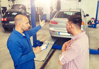 Image showing auto mechanic with clipboard and man at car shop