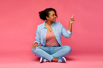 Image showing happy african american woman pointing finger up