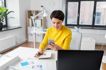 Image showing smiling ui designer using smartphone at office