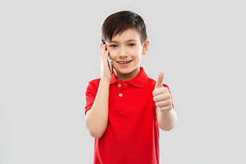 Image showing smiling boy in red t-shirt calling on smartphone