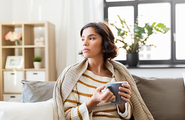 Image showing sad sick young woman drinking hot tea at home