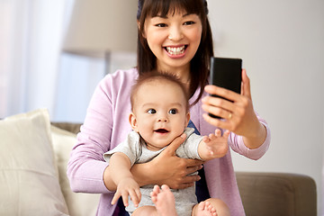 Image showing asian mother with baby son taking selfie at home