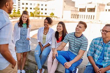 Image showing happy international friends talking in city