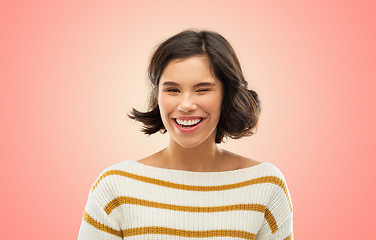 Image showing happy smiling woman in striped pullover winking