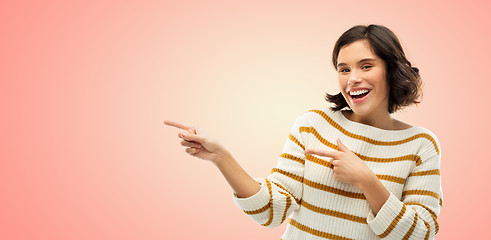 Image showing happy smiling woman pointing fingers to something