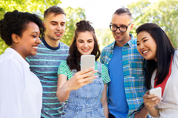Image showing happy friends with smartphone at summer park