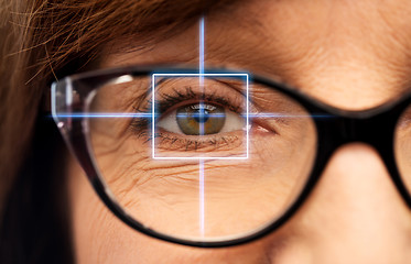 Image showing close up of senior woman eye with laser light