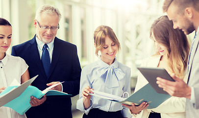 Image showing business team with tablet pc and folders at office