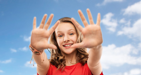 Image showing happy teenage girl in red t-shirt giving high five