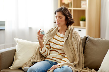 Image showing sad sick woman in blanket with drug at home