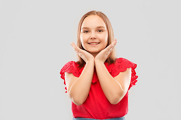 Image showing smiling girl in red shirt posing over grey