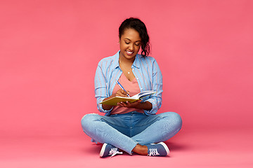 Image showing african student woman writing to diary or notebook