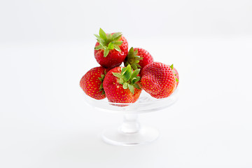 Image showing strawberries on glass stand over white background