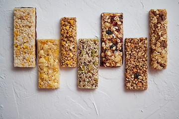 Image showing Row of mixed gluten free granola cereal energy bars. With dried fruits and nuts.