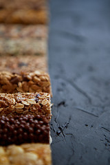 Image showing Row of mixed gluten free granola cereal energy bars. With dried fruits and nuts.