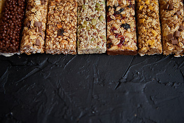 Image showing Row of mixed gluten free granola cereal energy bars. With dried fruits and nuts.