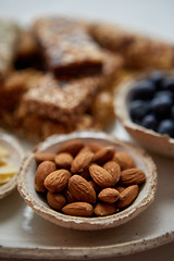 Image showing Close up of whole Almonds. With various energy nutrition bars in background