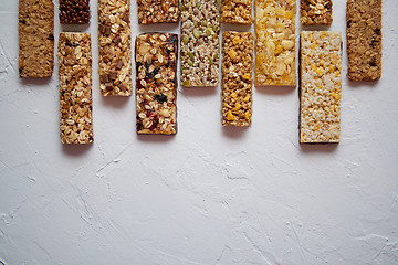 Image showing Row of mixed gluten free granola cereal energy bars. With dried fruits and nuts.